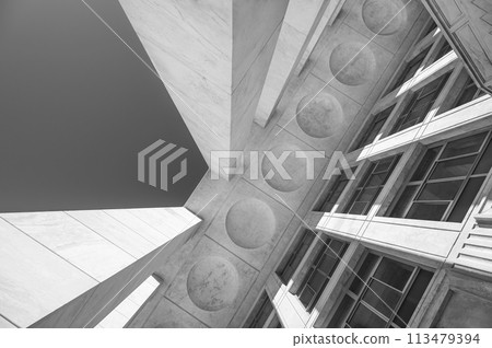 An architectural abstraction formed from marble columns, windows, and a geometric ceiling, shot at an angle. Black and white photo An architectural abstraction formed from marble columns, windows, and a geometric ceiling, shot at an angle. Black and white photo 113479394