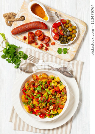 spanish potato salad with chorizo in white bowl spanish potato salad with chorizo in white bowl 113479764