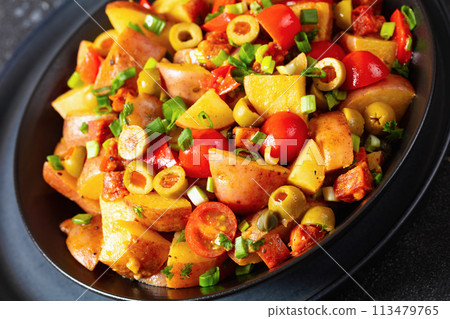 spanish potato salad with chorizo in black bowl spanish potato salad with chorizo in black bowl 113479765