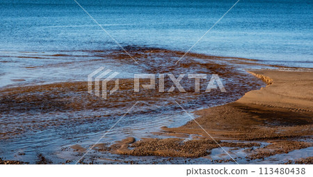 Gentle Waves Caressing The Patterned Sandy Shore. Gentle Waves Caressing The Patterned Sandy Shore. 113480438