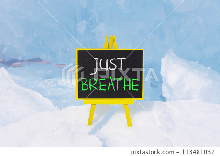 Just breathe and psychological symbol. Concept words Just breathe on beautiful yellow black blackboard. Beautiful blue ice background. Business psychological and Just breathe concept. Copy space 113481032