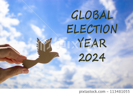 Global election year 2024 symbol. Concept words Global election year 2024. Beautiful blue sky cloud background. Voter hand with wooden bird. Business Global election year 2024 concept. Copy space Global election year 2024 symbol. Concept words Global election year 2024. Beautiful blue sky cloud background. Voter hand with wooden bird. Business Global election year 2024 concept. Copy space 113481055