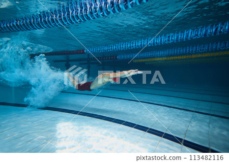 Water bubbles demonstrating speed. Young man, swimming athlete in motion in pool training, preparing for competition Water bubbles demonstrating speed. Young man, swimming athlete in motion in pool training, preparing for competition 113482116