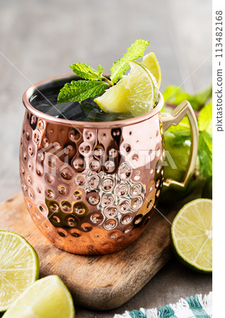Moscow mule cocktail served with ice and slice of lime on wooden table. Moscow mule cocktail served with ice and slice of lime on wooden table. 113482168