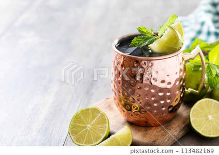Moscow mule cocktail served with ice and slice of lime on wooden table. Copy space Moscow mule cocktail served with ice and slice of lime on wooden table. Copy space 113482169