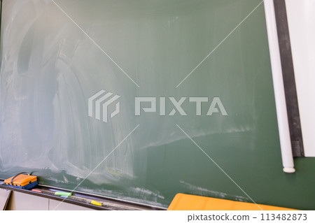 School blackboard. Faintly remaining letters on the blackboard. School blackboard. Faintly remaining letters on the blackboard. 113482873