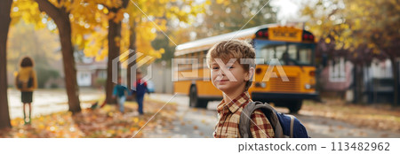 A Caucasian male schoolboy carrying a backpack is traveling on a school bus. 113482962