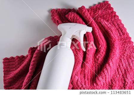 Cleaning product with a sprayer on a background of a red microfiber cloth. 113483651