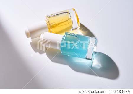 Yellow and blue serums with pipettes against the background of the sun. 113483689