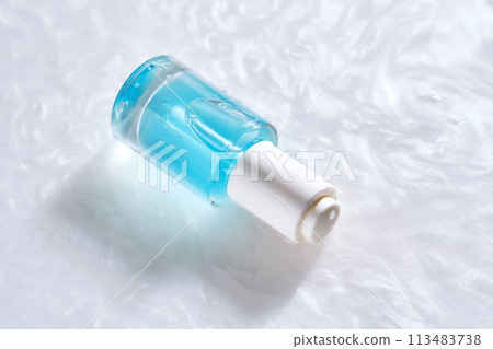 Bottles of serum with a dropper in liquid with pearl tints. 113483738