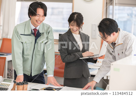 Three male and female engineers having a meeting in an office 113484512