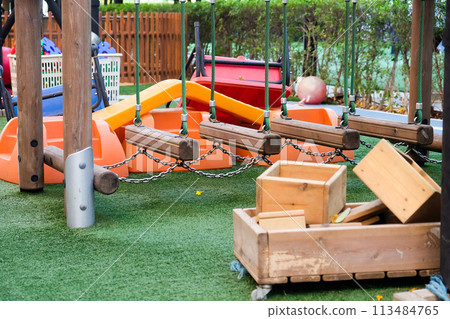 Empty playground with various equipment and toys on green synthetic grass 113484765