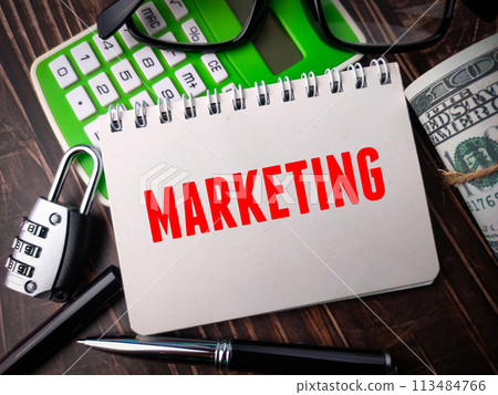 Top view padlock,pen,calculator,glasses and banknotes with text MARKETING on wooden background. 113484766