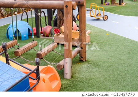 Empty playground with various equipment and toys on green synthetic grass Empty playground with various equipment and toys on green synthetic grass 113484770
