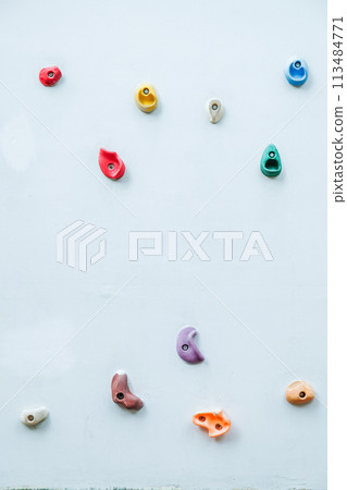 Colorful climbing holds on wall for outdoor rock climbing 113484771