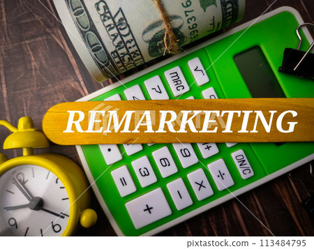 Top view clock,calculator,banknotes and colored ice cream stick with text REMARKETING on wooden background. 113484795