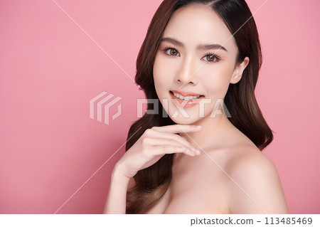 Beautiful young asian woman with clean fresh skin on pink background, Face care, Facial treatment, Cosmetology, beauty and spa, Asian women portrait. Beautiful young asian woman with clean fresh skin on pink background, Face care, Facial treatment, Cosmetology, beauty and spa, Asian women portrait. 113485469