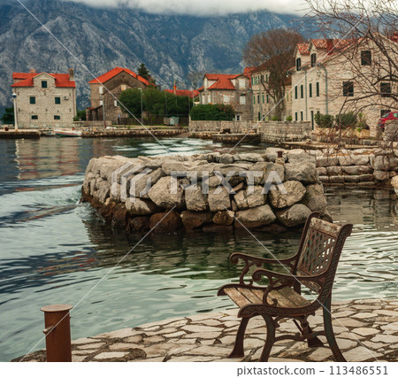 View of the Bay of Kotor and the mountains from the shore on a bench 113486551
