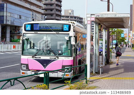 "Shuttle Seven" (Isuzu Erga), a Kan-nana shuttle bus, stops at a bus stop "Shuttle Seven" (Isuzu Erga), a Kan-nana shuttle bus, stops at a bus stop 113486989