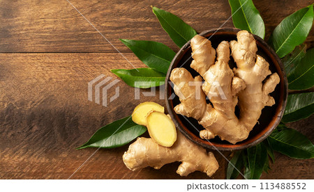 Ginger Roots and Ginger Slices on a Wooden Table with Copy Space - Generative Ai 113488552