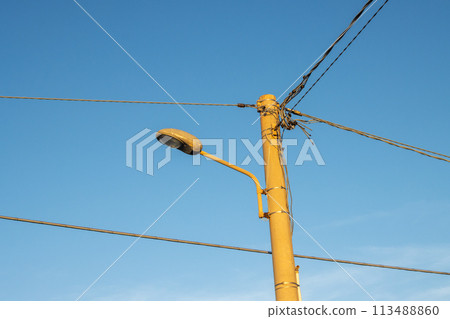 Streetlamp with cables and bright blue sky, Italy Streetlamp with cables and bright blue sky, Italy 113488860