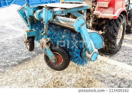 Brushes of street cleaning machine on street in winter 113489162