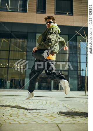 Stylish student, dressed oversized neon outfit merging urban chic with youthful exuberance against cityscapes. Stylish student, dressed oversized neon outfit merging urban chic with youthful exuberance against cityscapes. 113489361