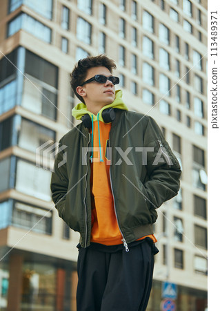 Cool attitude student shows his street style by dressing in neon fashions that speak to his trendy approach to city life. Cool attitude student shows his street style by dressing in neon fashions that speak to his trendy approach to city life. 113489371