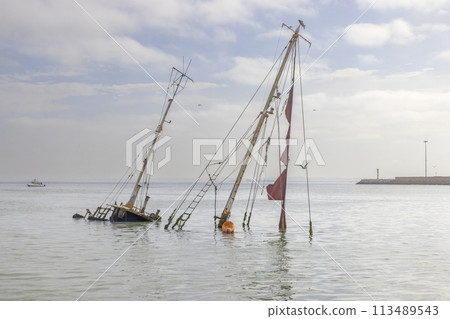 Picture of a sunken sailing yacht with masts sticking out of the water near Walvis Bay in Namibia 113489543