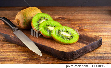 Slices of Kiwi on a Wooden Cutting Board with a Table Knife - Generative Ai 113489633