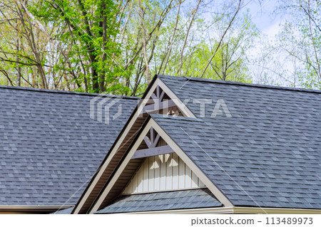 Roofing shingles cover roof top of newly constructed house 113489973