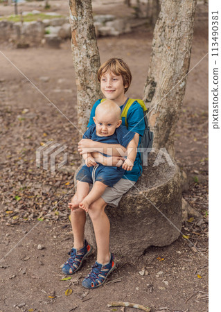 Happy laughing teen boy holding his baby brother 113490381