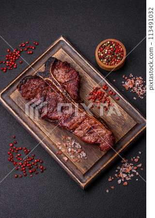 Delicious juicy beef tbone steak with salt, spices and herbs Delicious juicy beef tbone steak with salt, spices and herbs 113491032