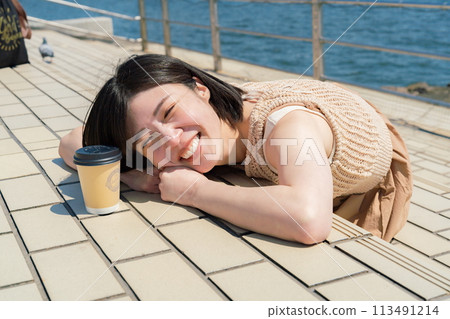 A woman relaxing by the sea 113491214