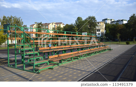 a small stand for spectators at a school stadium a small stand for spectators at a school stadium 113491379