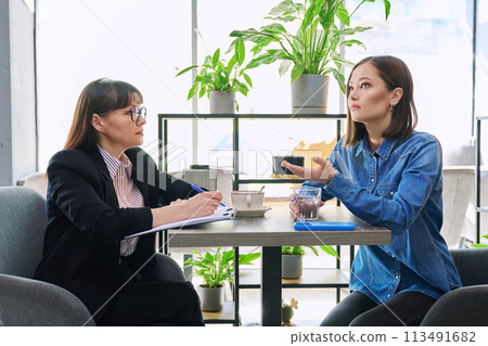 Young female patient at therapy meeting with psychologist, mental therapist 113491682