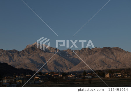 The white peak of Mt. Kaikoma in the Southern Alps bathed in the morning sun, and the townscape at its base 113491914