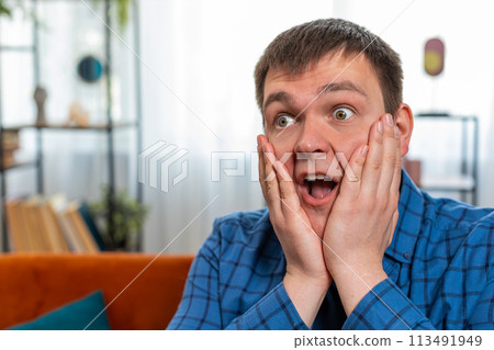 Excited shocked amazed young man surprised looking at camera with big eyes wow emotion good win news Excited shocked amazed young man surprised looking at camera with big eyes wow emotion good win news 113491949