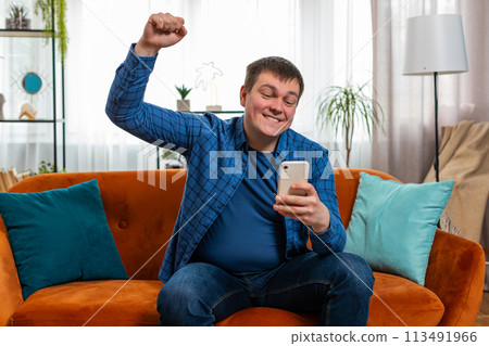 Surprised excited man holding smartphone reading good news amazed by online bet bid game win victory Surprised excited man holding smartphone reading good news amazed by online bet bid game win victory 113491966