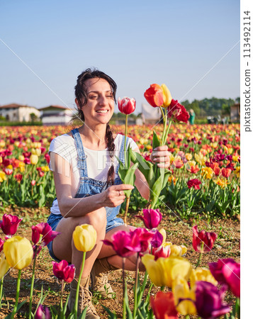 happy female workers trimming flowers in greenhouse happy female workers trimming flowers in greenhouse 113492114