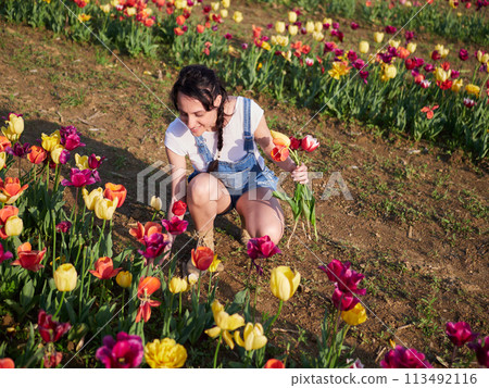 happy female workers trimming flowers in greenhouse 113492116