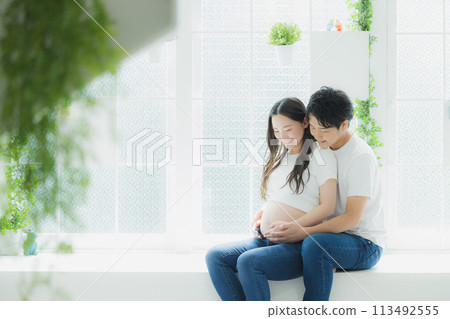 A husband supporting a pregnant woman A husband supporting a pregnant woman 113492555