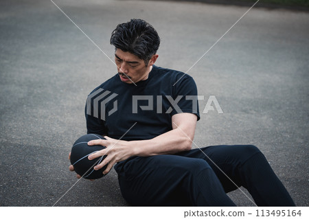 A man in his 40s doing strength training outdoors 113495164