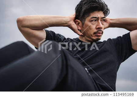 A man in his 40s doing strength training outdoors A man in his 40s doing strength training outdoors 113495169