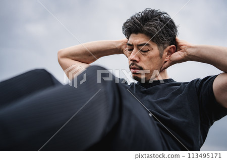 A man in his 40s doing strength training outdoors A man in his 40s doing strength training outdoors 113495171