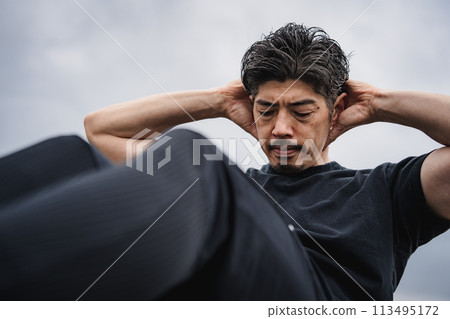 一名40多歲的男子在戶外進行肌肉訓練 113495172