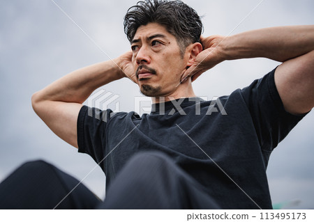 A man in his 40s doing strength training outdoors A man in his 40s doing strength training outdoors 113495173
