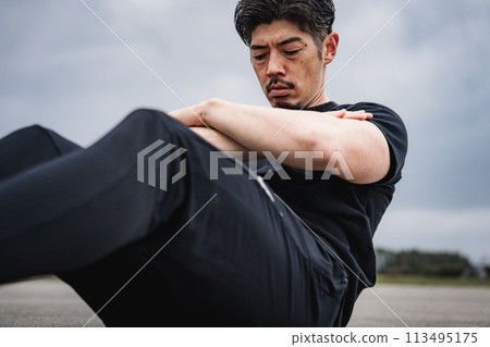 一名40多歲的男子在戶外進行肌肉訓練 一名40多歲的男子在戶外進行肌肉訓練 113495175