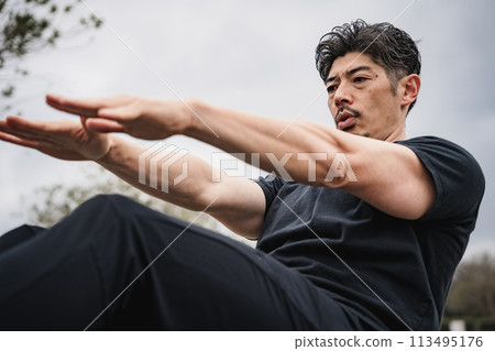A man in his 40s doing strength training outdoors A man in his 40s doing strength training outdoors 113495176