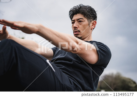A man in his 40s doing strength training outdoors A man in his 40s doing strength training outdoors 113495177